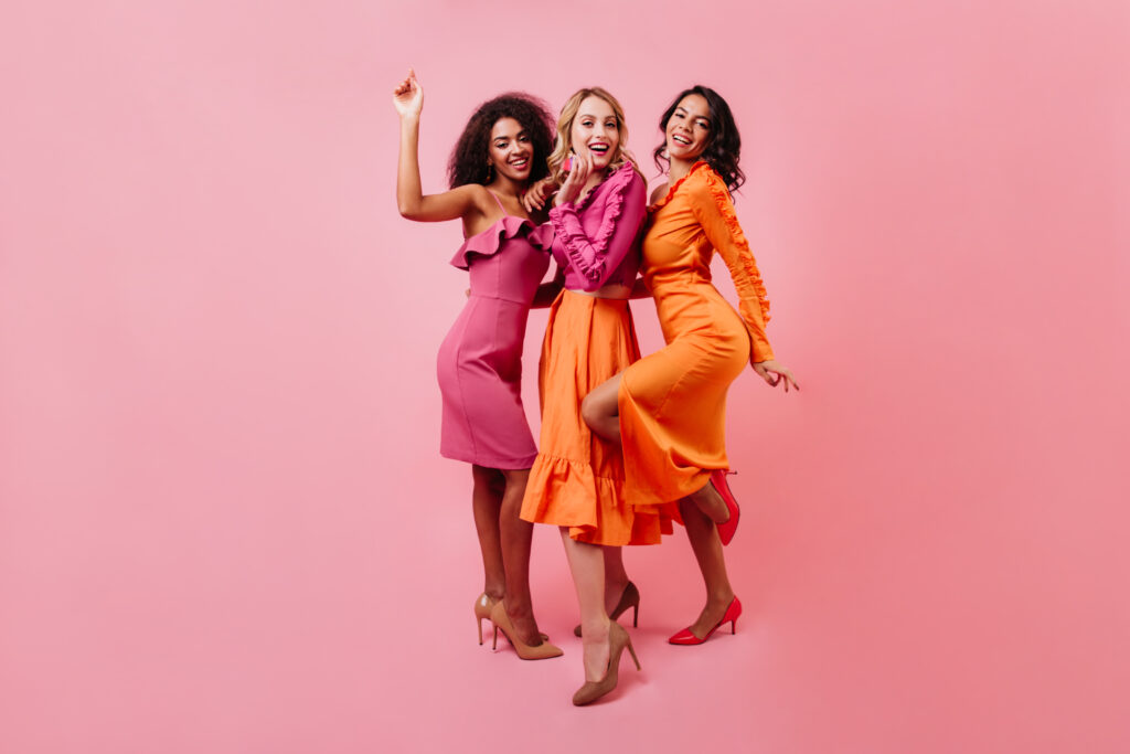 three-women-posing-in-colorful-dresses-on-pink-2026-01-05-01-24-35-utc